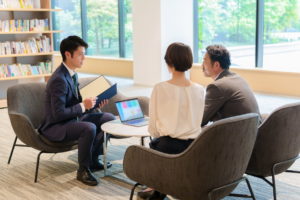 銀行員にローン返済の相談をする夫婦